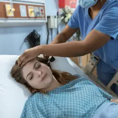 Pielęgniarka bada pacjentkę w szpitalu. Zastanawiasz się, ile zarabia pielęgniarka?