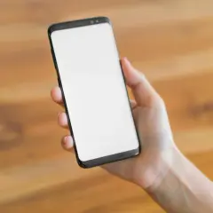 Dłoń trzyma smartfon z pustym ekranem. Czekam na ważny telefon, bo mam dyżur.