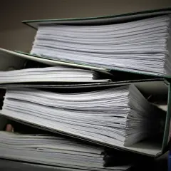 Stosy dokumentów w segregatorach, gotowe do złożenia jako list motywacyjny do urzędu.