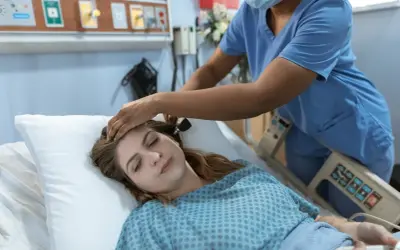 Pielęgniarka bada pacjentkę w szpitalu. Zastanawiasz się, ile zarabia pielęgniarka?