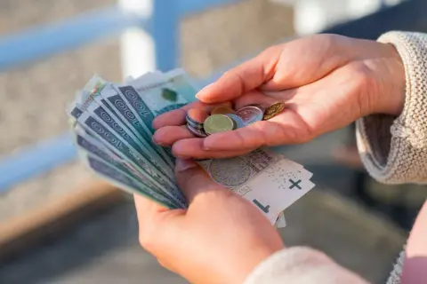 Dłonie liczą polskie banknoty i monety. Zastanawiasz się, ile to netto przy 3/4 etatu?