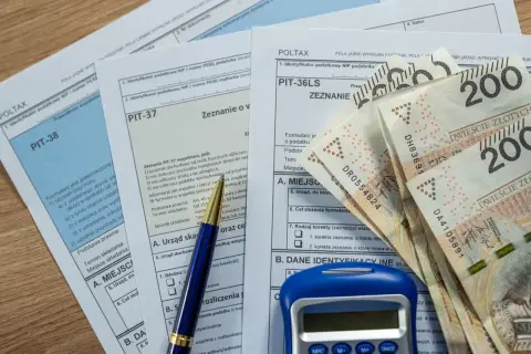 Formularze PIT-38, PIT-37, PIT-36LS, długopis, kalkulator i banknoty 200 zł. Rozliczenie podatkowe w **pit 8** roku.