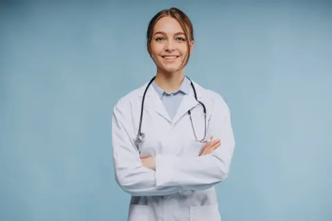Uśmiechnięta lekarka w białym kitlu ze stetoskopem, zastanawia się, ile zarabia psychiatra.