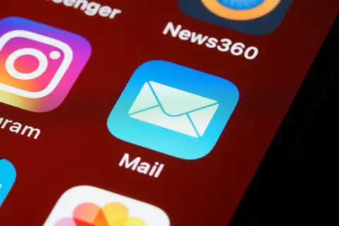 Ikona aplikacji Mail na ekranie smartfona. Zastanawiasz się, jak zakończyć maila? Kliknij tutaj, aby się dowiedzieć.