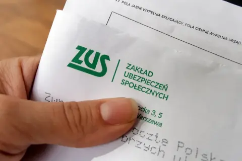 Dłoń trzyma dokument ZUS. To ważny krok w kierunku odprawy emerytalnej w prywatnej firmie.
