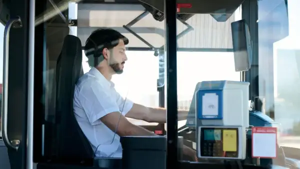 Mężczyzna za kierownicą autobusu. Zastanawiasz się, ile zarabia kierowca autobusu?