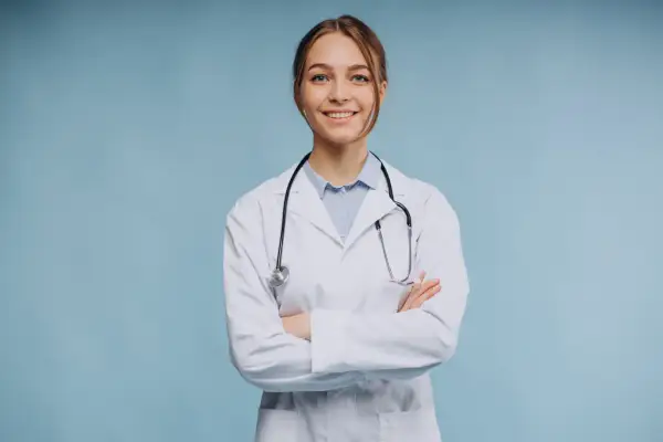 Uśmiechnięta lekarka w białym kitlu ze stetoskopem, zastanawia się, ile zarabia psychiatra.
